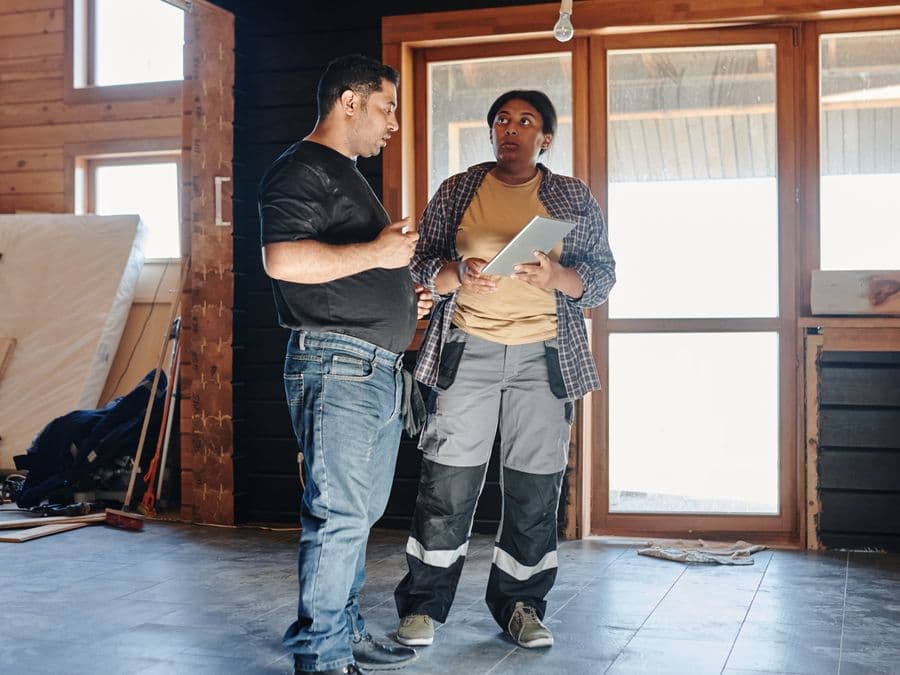 Two contractors talking in a home mid-renovation